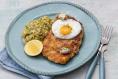 Chicken schnitzel with fried egg, garlic butter and creamed leeks